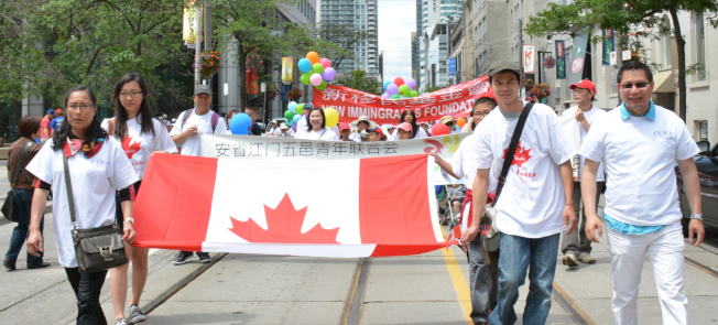 国庆大游行声势浩大，游行队伍牵着大幅加拿大国旗，表达对加拿大的热爱。 （记者谢君/摄影）