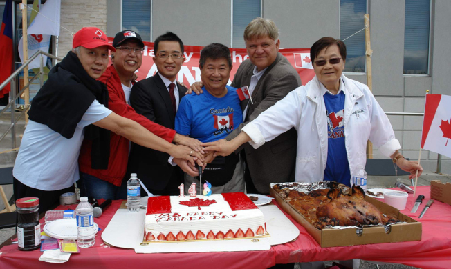 八侨团切蛋糕共同庆祝加拿大148岁生日。自右至左为麦锦鸿、詹嘉礼、陈荫庭、欧阳群、金声白、陈符康。 （记者葛健生／摄影）