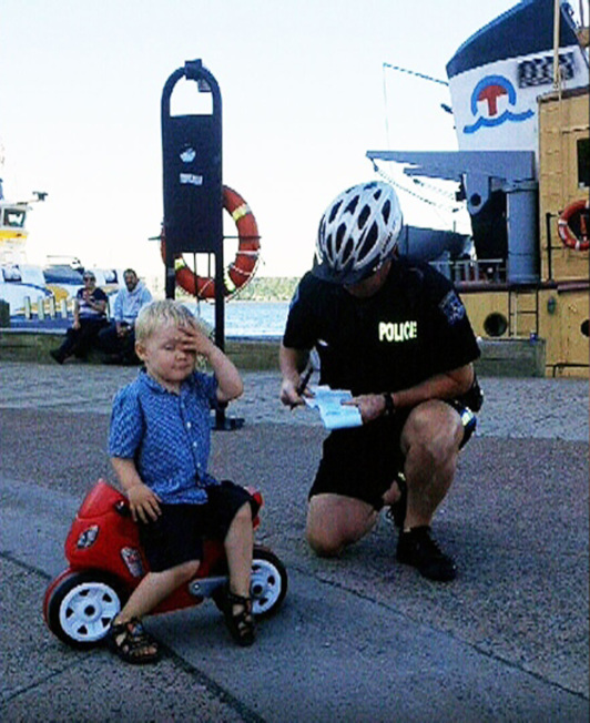 哈利法克斯的警员柯瑞近日在海滨码头看到三岁小男童崔姆雷将他的红色塑胶摩托车「非法」停在码头上时，便装模作样开了张「罚单」给那小家伙。柯瑞随后在哈利法克斯地区警察局的脸书上公布了这张「三岁小男童获发人生首张交通罚单」的照片，这张一脸严肃相的警察和苦恼小男童的生动照片，立即受到人们的好评。截止至周一，在脸书上分享的人即超过1万，在推特上也获数千人转发。 （CTV）