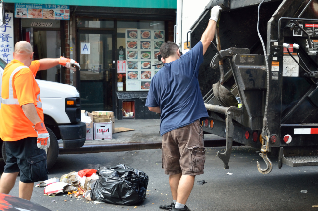 垃圾袋太重，经常造成收垃圾员把袋子拽破。 (记者朱泽人/摄影)