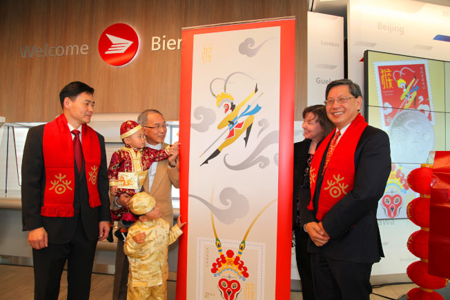 中國駐多倫多總領事薛冰（左一）、猴年郵票設計師伍啟榮（左二）等共同為猴票揭幕。（中新社）